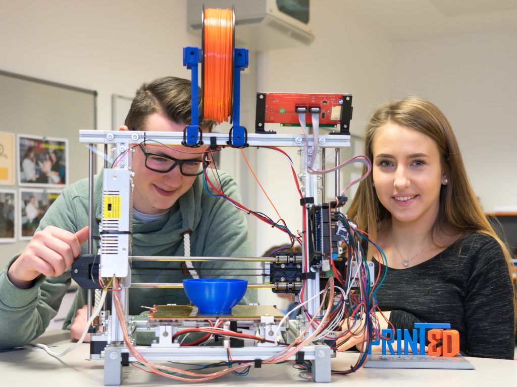 Schüler:innen beim Arbeiten am 3D-Drucker